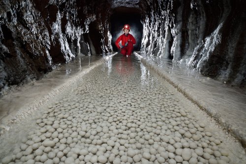 Spéléodrome de Villers-lès-Nancy - Galerie avec parois recouvertes de calcite et perles des cavernes au sol (avec personnage accroupi en fond, format horizontal )(SP-19-1918 )